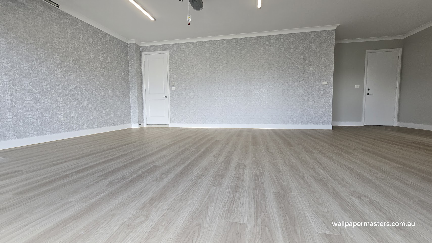 Cool grey oak flooring installed across a large finished room