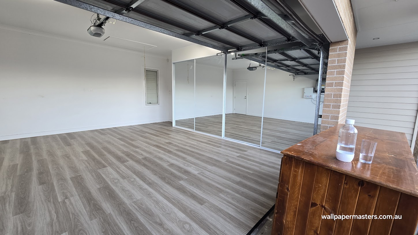 Grey wood-look flooring installed in a garage with mirrored storage